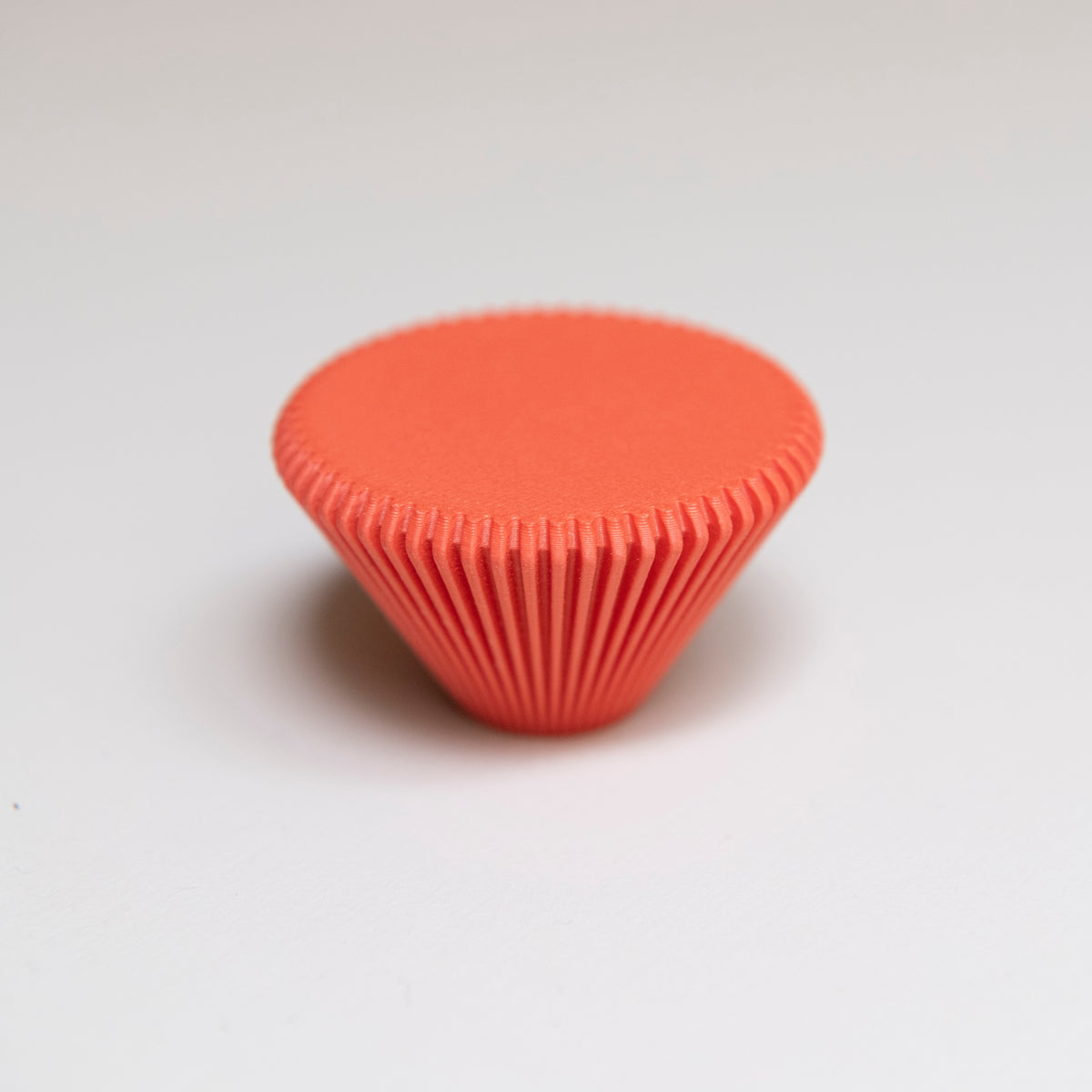 Bouton de meuble Cornet couleur rouge-orangé, créé en collaboration entre Studio Couleur et Polycoco, en bioplastique éco-responsable.