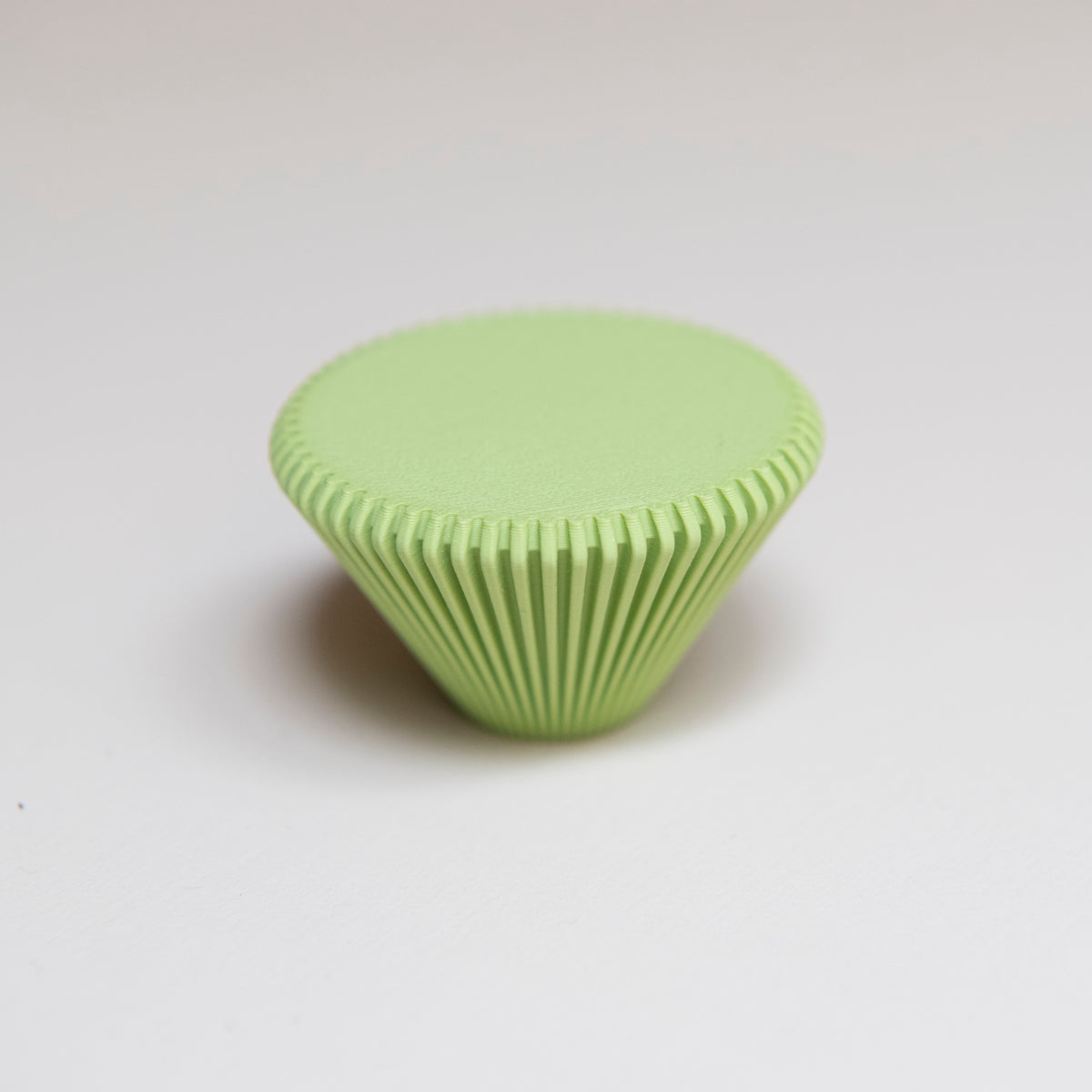 Bouton de meuble Cornet couleur vert pistache, créé en collaboration entre Studio Couleur et Polycoco, en bioplastique éco-responsable.