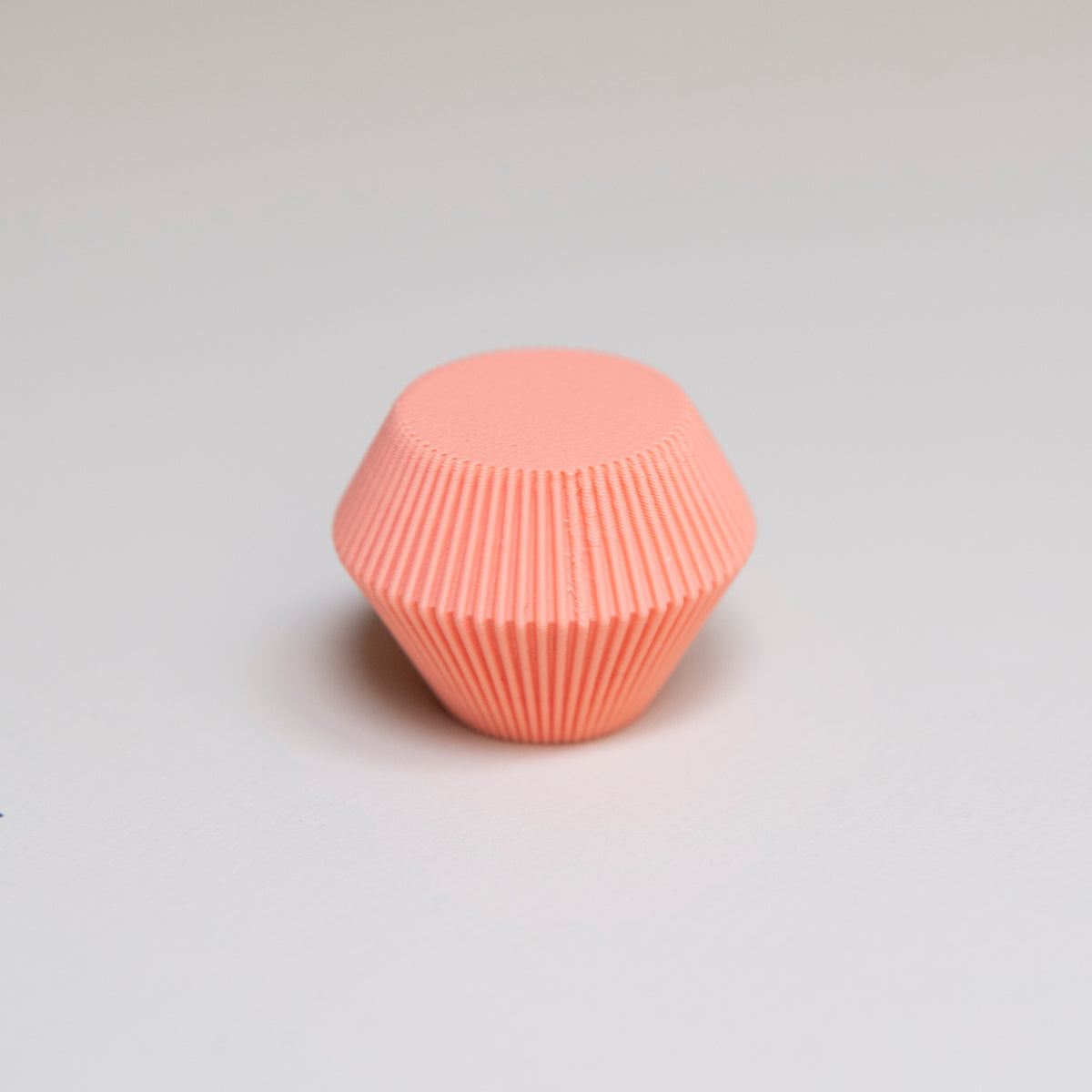 Bouton de meuble Facette couleur corail, créé en collaboration entre Studio Couleur et Polycoco, en bioplastique éco-responsable.