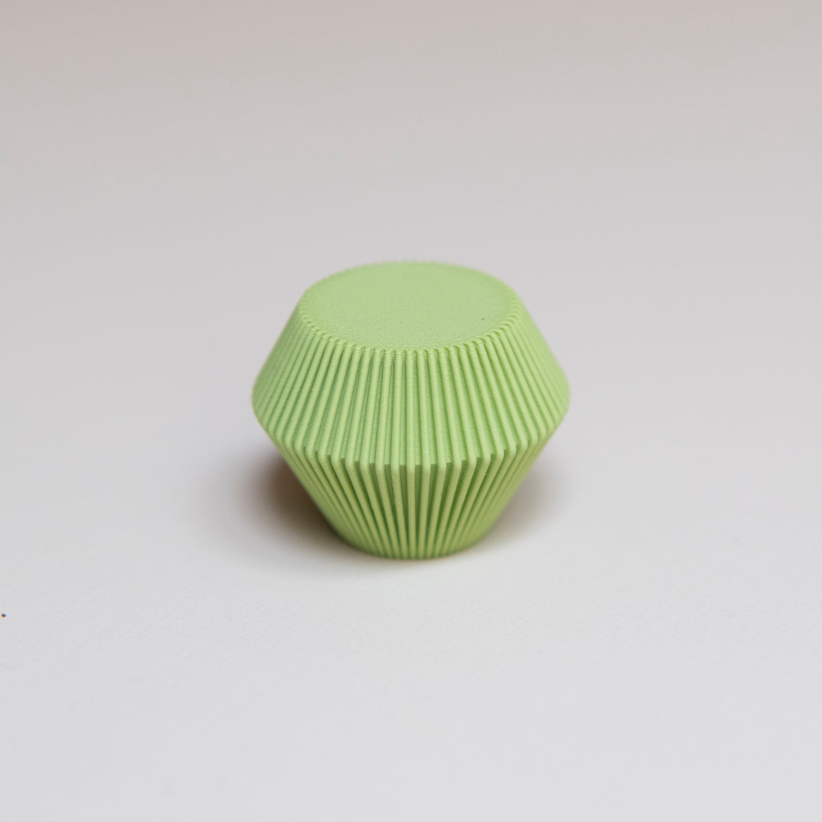 Bouton de meuble Facette couleur vert pistache créé en collaboration entre Studio Couleur et Polycoco, en bioplastique éco-responsable.