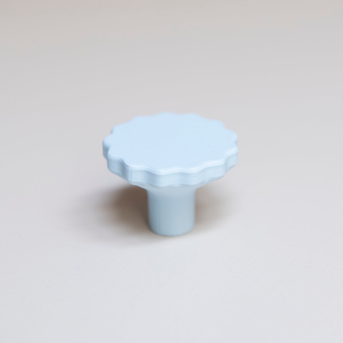 Bouton de meuble Manège couleur bleu pâle, créé en collaboration par Polycoco et Studio Couleur, en bioplastique éco-responsable.