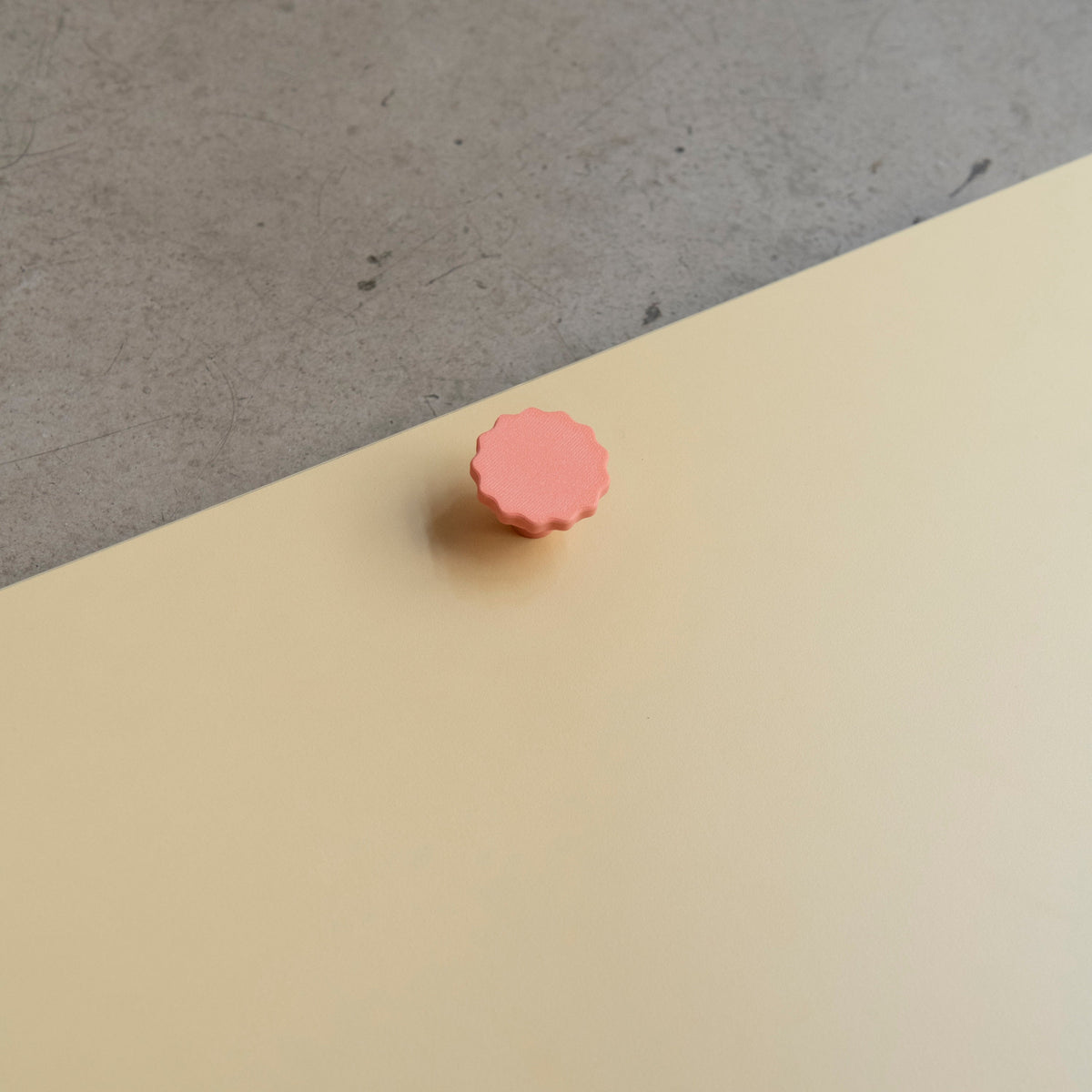 Bouton de meuble Manège couleur corail, créé en collaboration par Polycoco et Studio Couleur, en bioplastique éco-responsable.