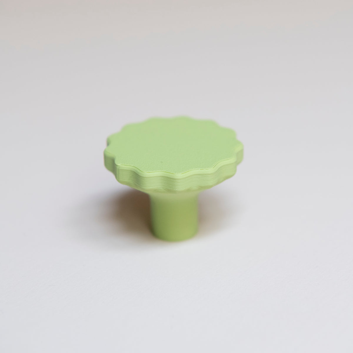 Bouton de meuble Manège couleur vert pistache, créé en collaboration par Polycoco et Studio Couleur, en bioplastique éco-responsable.