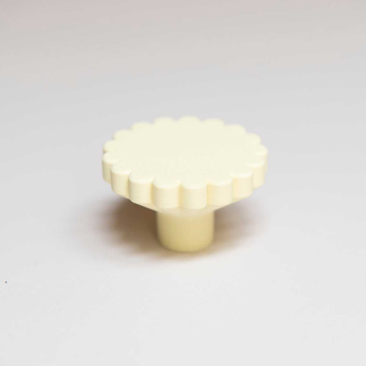 Bouton de meuble Marguerite couleur jaune pâle, créé en collaboration entre Studio Couleur et Polycoco, en bioplastique éco-responsable.