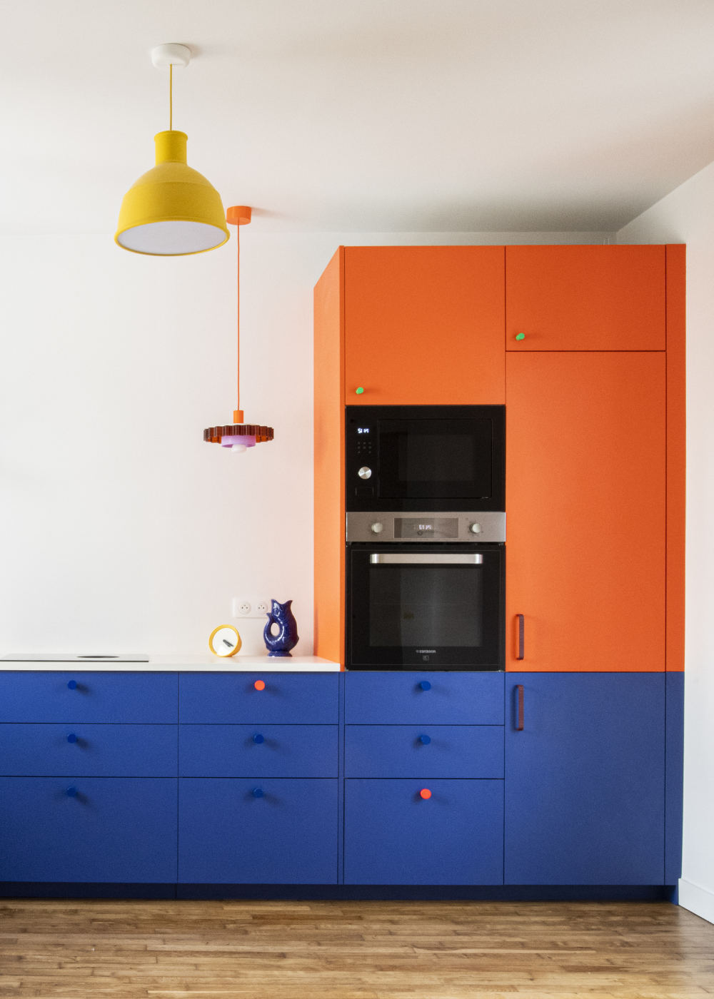 Cuisine moderne aux façades bleu roi et orange montée sur caissons Ikea Metod