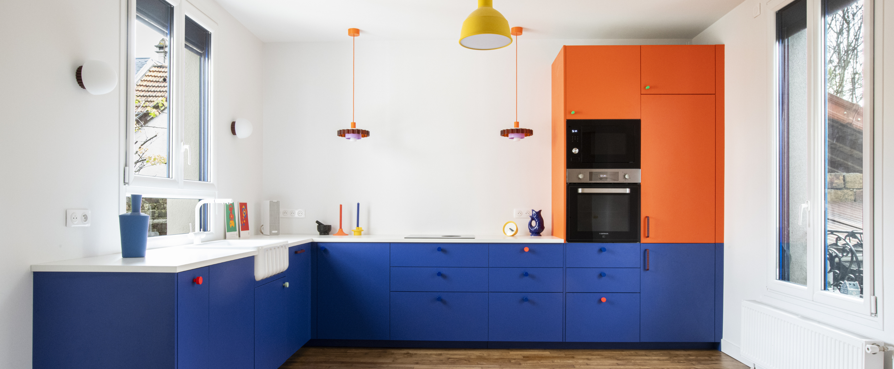 Grande cuisine moderne aux portes bleu roi et orange montée sur caissons Ikea Metod