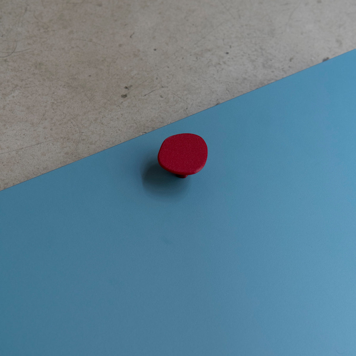 Poignée de porte de cuisine forme Galet de couleur rouge, collaboration Studio Couleur et Polycoco. Matériau recyclé.