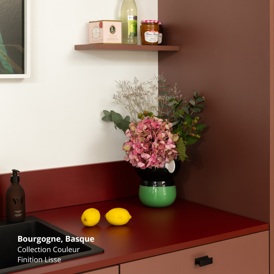 Plan de travail et crédence de cuisine rouge foncé coloris "Basque" Studio Couleur. Meubles bas de petite cuisine Ikea Metod aux façades de tiroir lisses rouge bordeaux coloris "Bourgogne", et panneau de finition coordonné. Poignées de tiroir rectangulaires noires. 