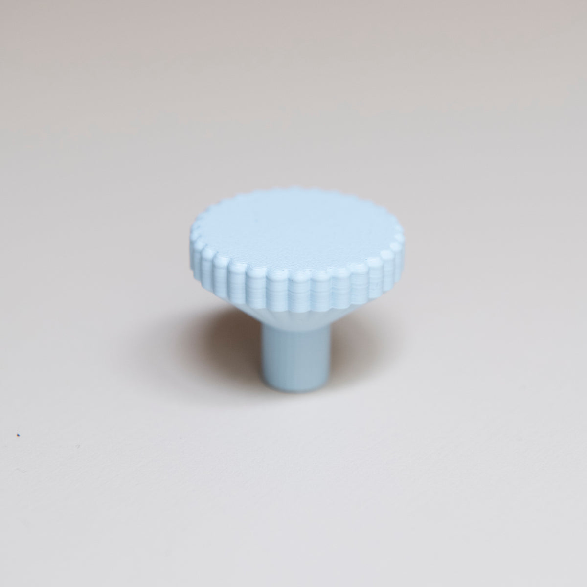 Bouton de meuble Biscuit couleur bleu pâle, créé en collaboration entre Studio Couleur et Polycoco, en bioplastique éco-responsable. 