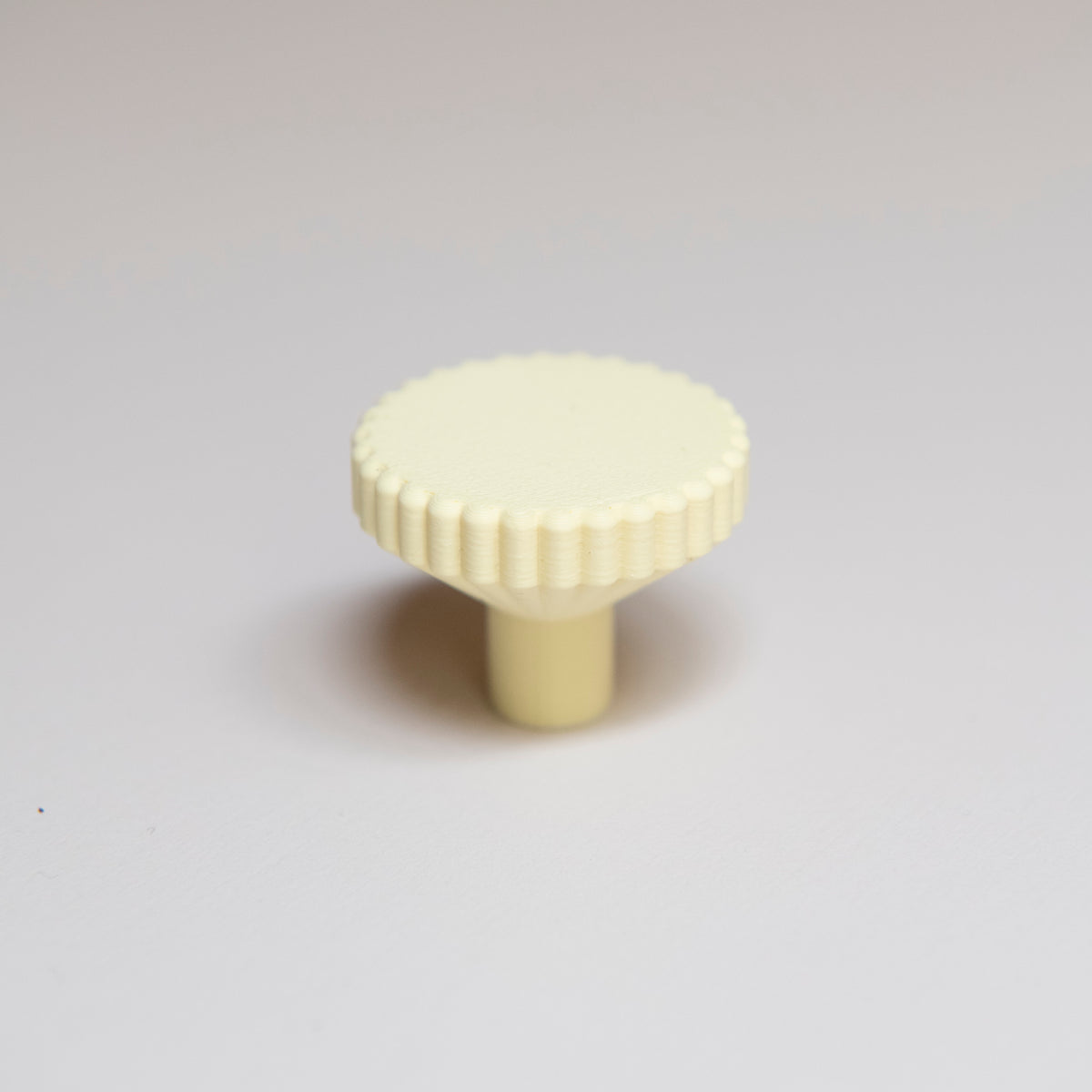Bouton de meuble Biscuit couleur jaune pâle, créé en collaboration entre Studio Couleur et Polycoco, en bioplastique éco-responsable. 