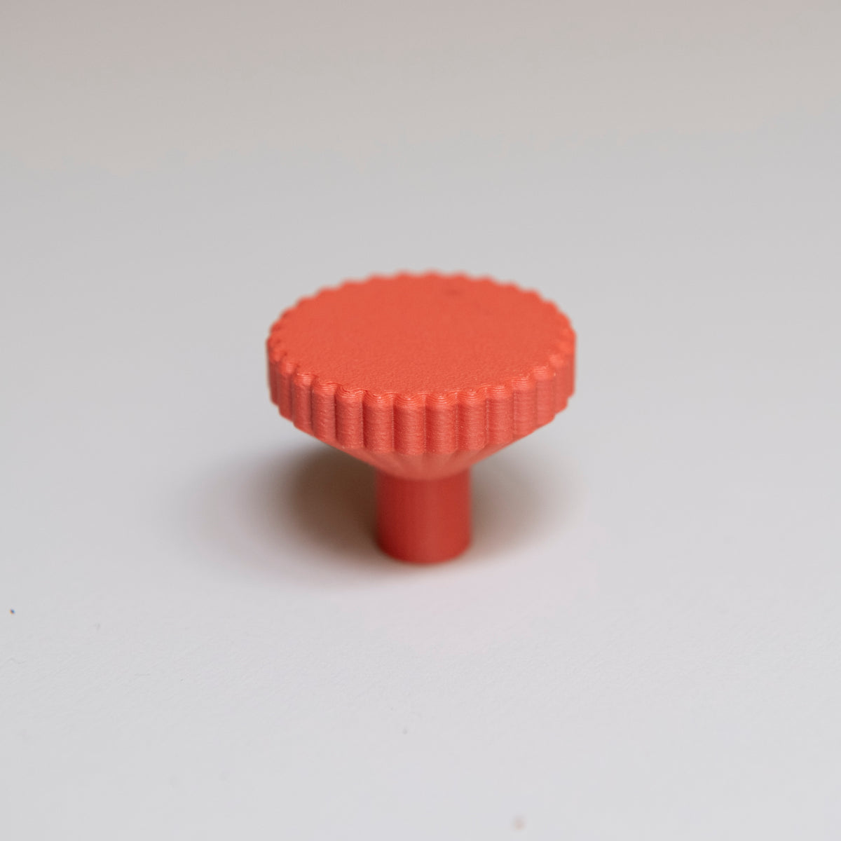 Bouton de meuble Biscuit couleur rouge-orangé, créé en collaboration entre Studio Couleur et Polycoco, en bioplastique éco-responsable. 