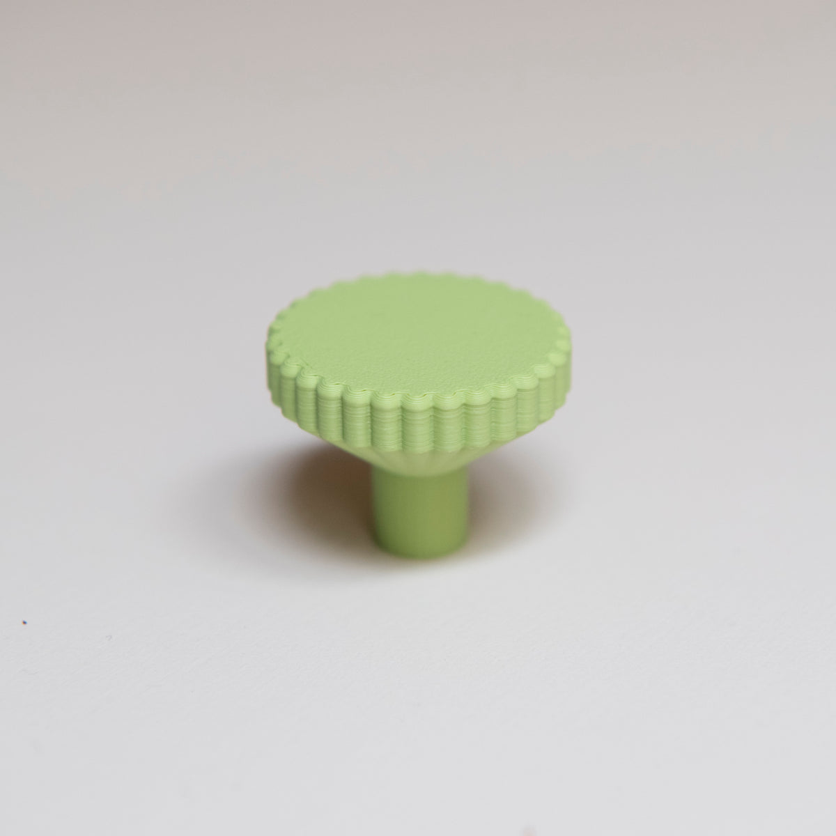 Bouton de meuble Biscuit couleur vert pistache, créé en collaboration entre Studio Couleur et Polycoco, en bioplastique éco-responsable. 