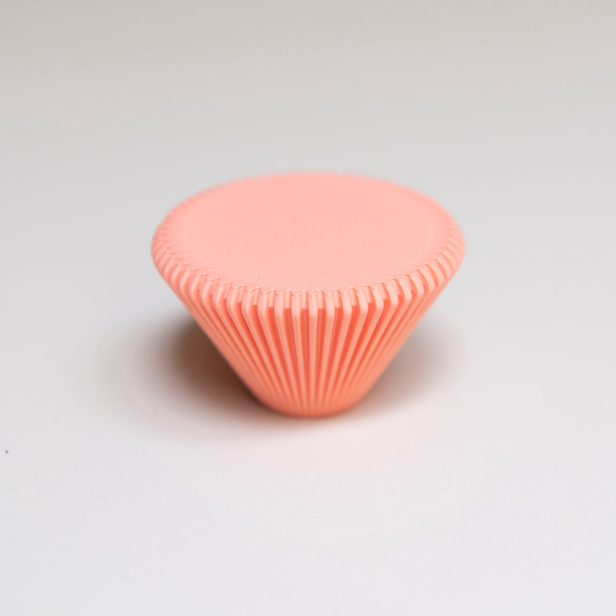 Bouton de meuble Cornet couleur corail, créé en collaboration entre Studio Couleur et Polycoco, en bioplastique éco-responsable. 