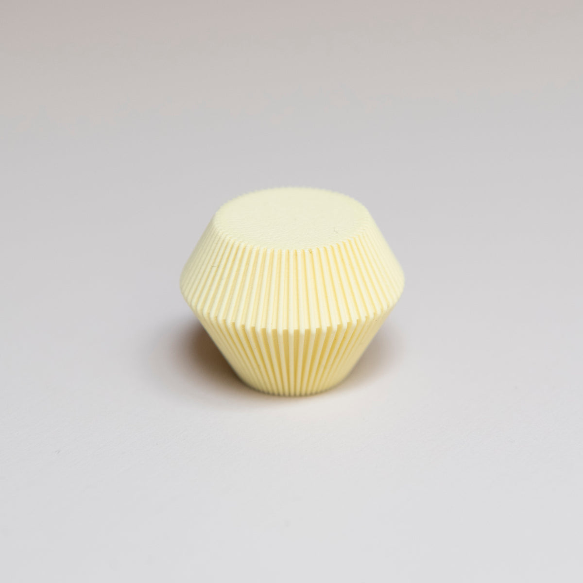 Bouton de meuble Facette couleur jaune clair, créé en collaboration entre Studio Couleur et Polycoco, en bioplastique éco-responsable. 