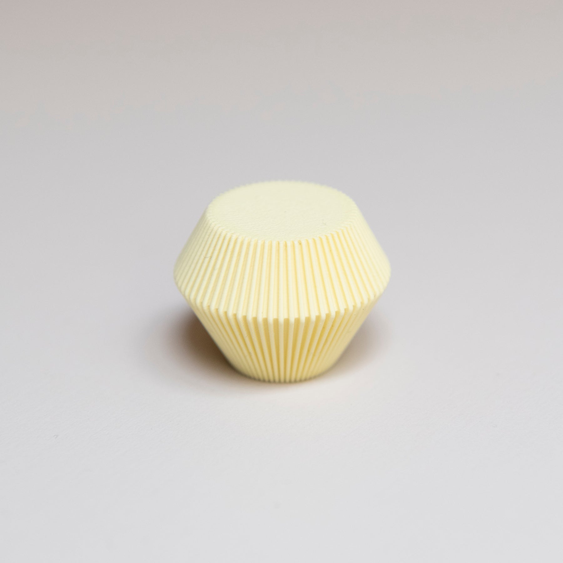 Bouton de meuble Facette couleur jaune clair, créé en collaboration entre Studio Couleur et Polycoco, en bioplastique éco-responsable. 