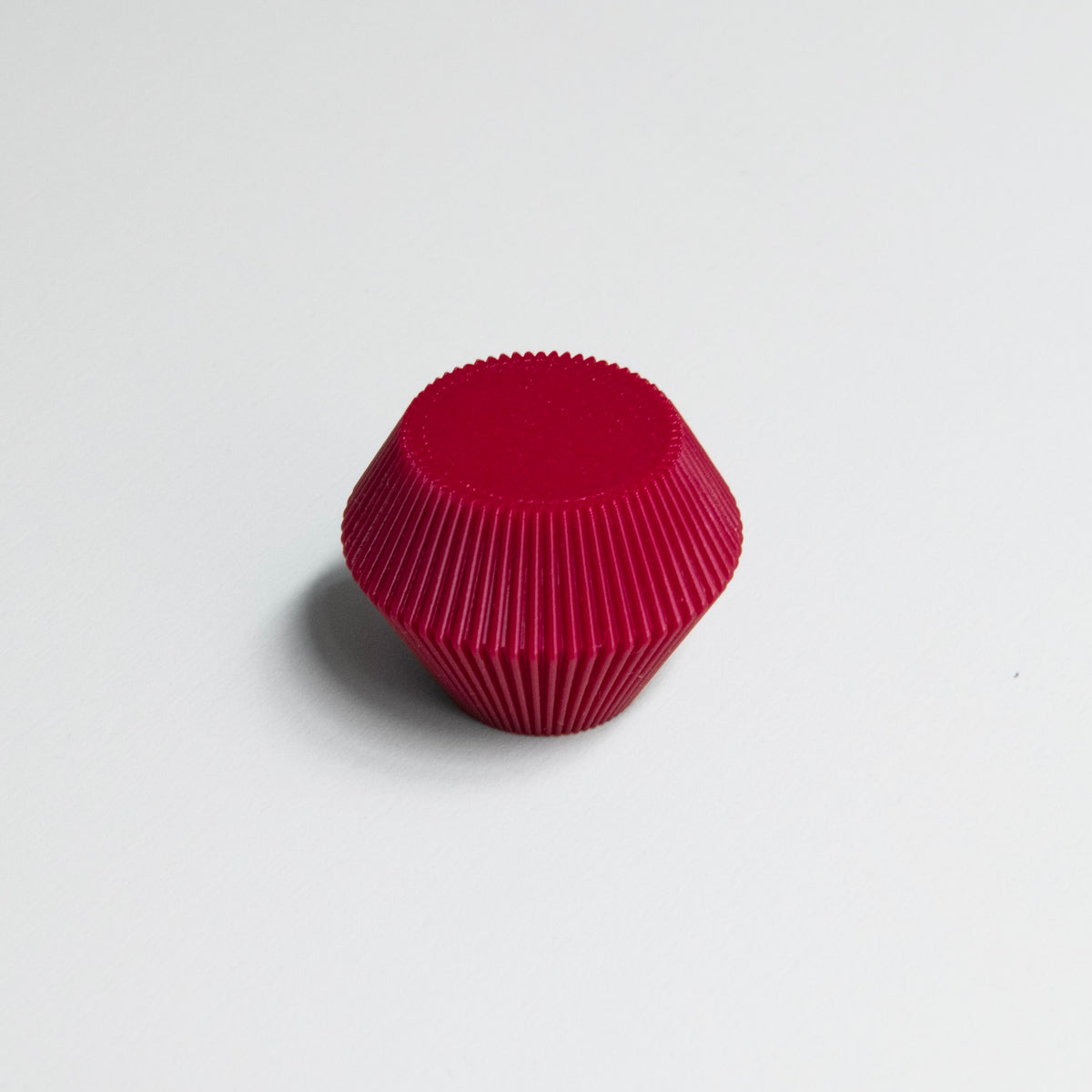 Bouton de meuble Facette couleur rouge, créé en collaboration entre Studio Couleur et Polycoco, en bioplastique éco-responsable. 