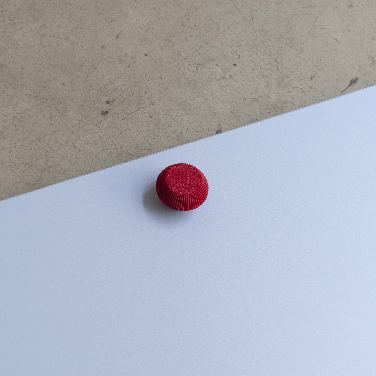 Bouton de meuble Facette couleur rouge, créé en collaboration entre Studio Couleur et Polycoco, en bioplastique éco-responsable. 
