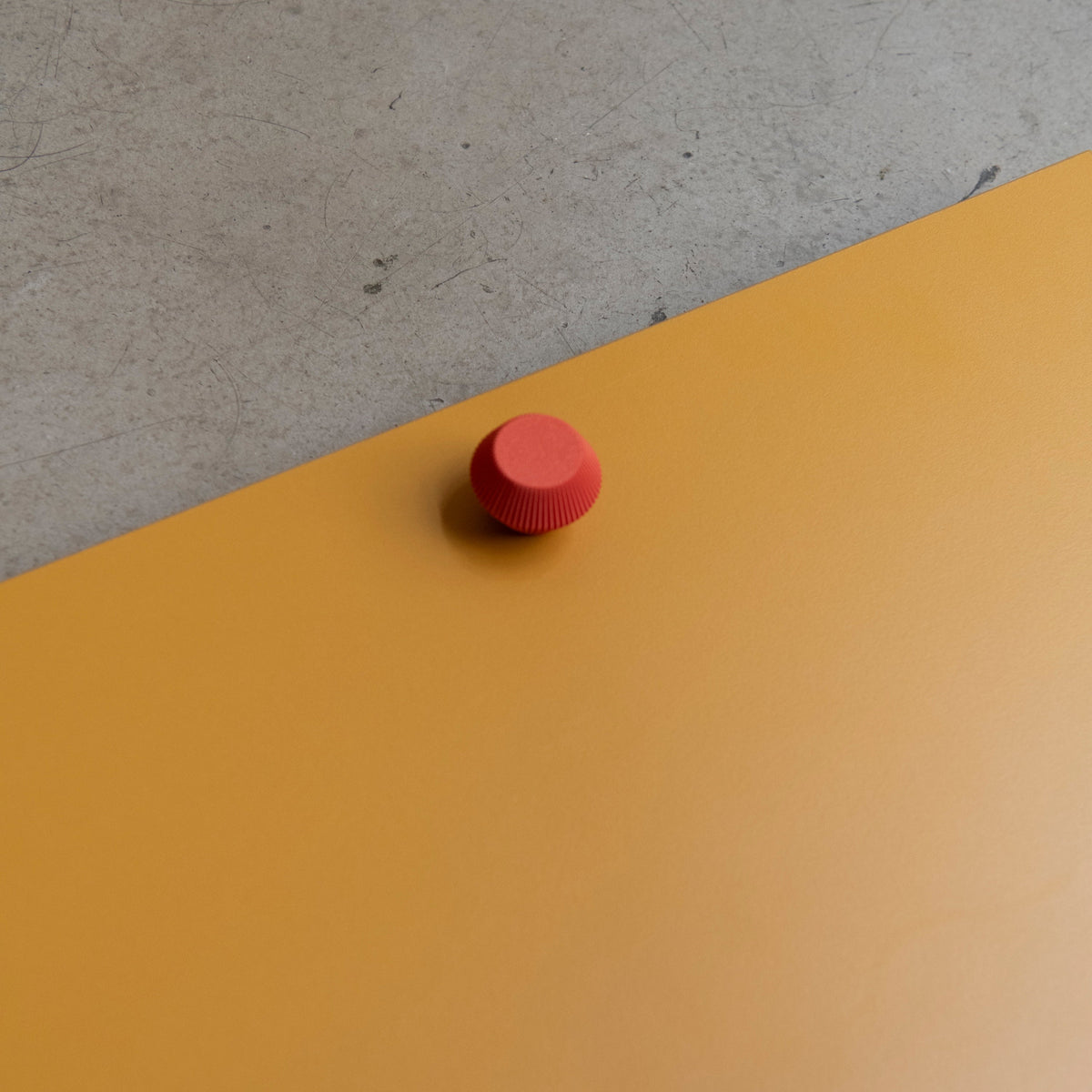Bouton de meuble Facette couleur rouge-orangé, créé en collaboration entre Studio Couleur et Polycoco, en bioplastique éco-responsable. 