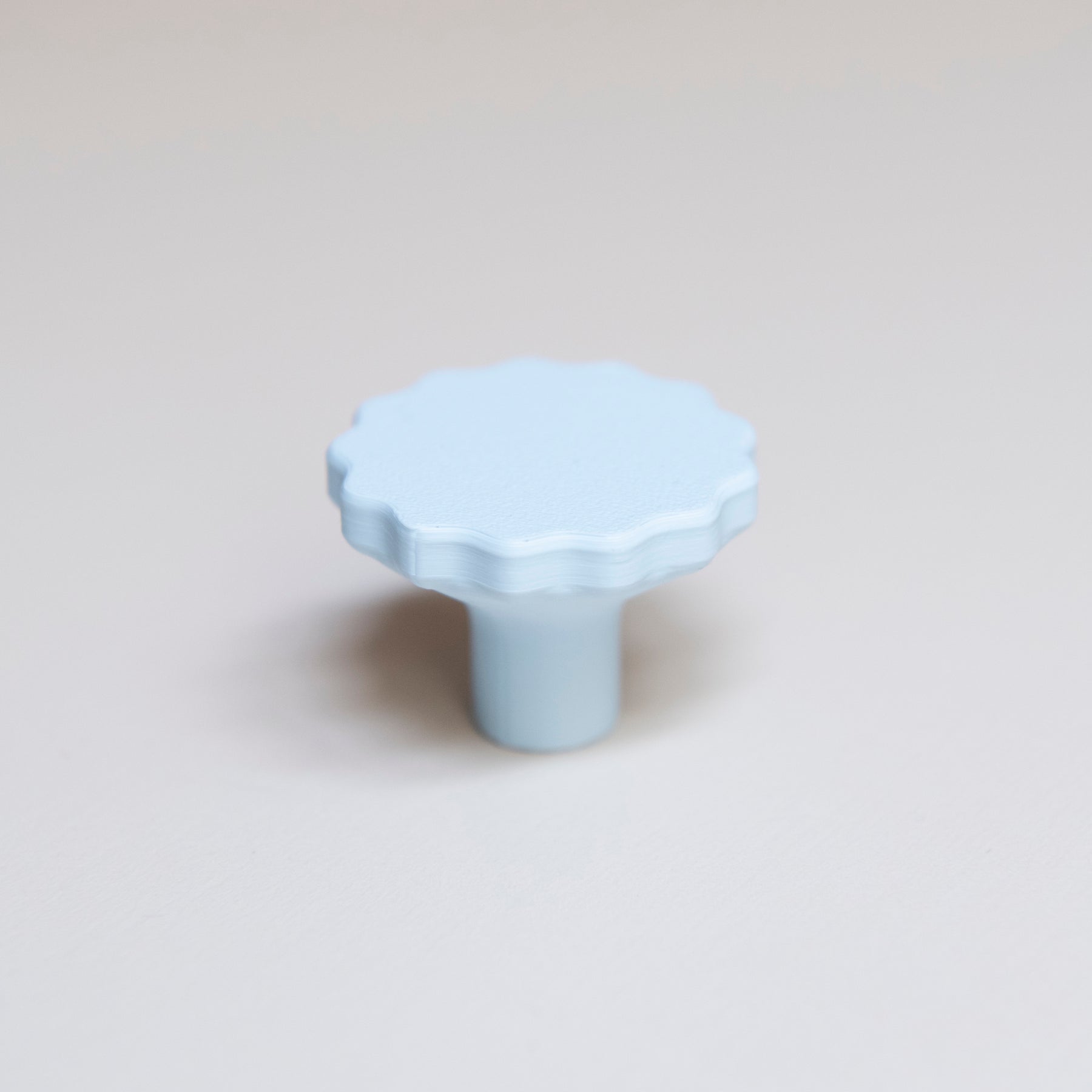 Bouton de meuble Manège couleur bleu pâle, créé en collaboration par Polycoco et Studio Couleur, en bioplastique éco-responsable. 