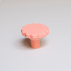 Bouton de meuble Manège couleur corail, créé en collaboration par Polycoco et Studio Couleur, en bioplastique éco-responsable. 