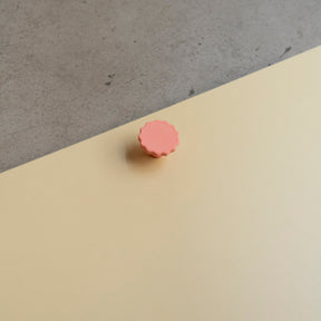 Bouton de meuble Manège couleur corail, créé en collaboration par Polycoco et Studio Couleur, en bioplastique éco-responsable. 