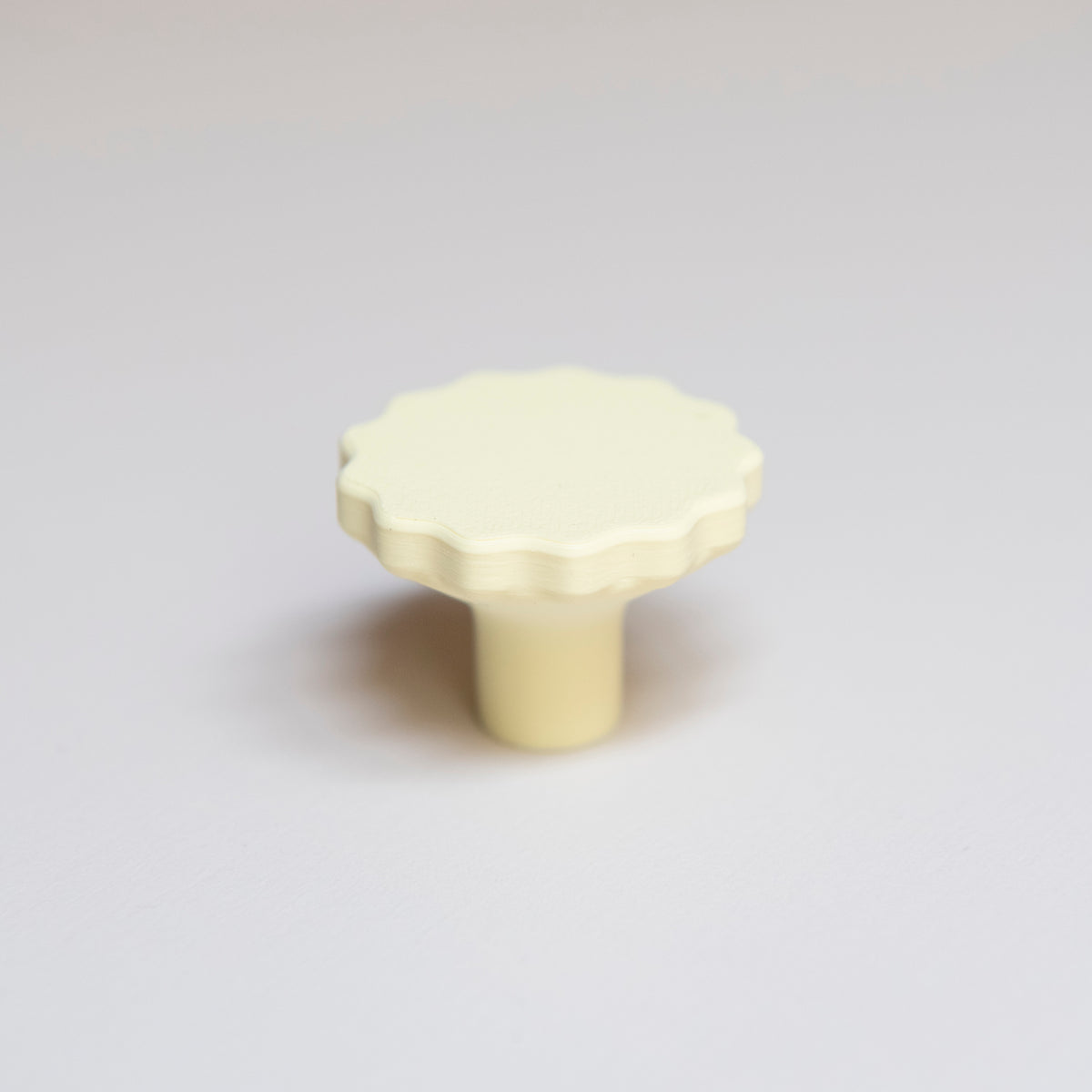 Bouton de meuble Manège couleur jaune pâle, créé en collaboration entre Studio Couleur et Polycoco, en bioplastique éco-responsable. 