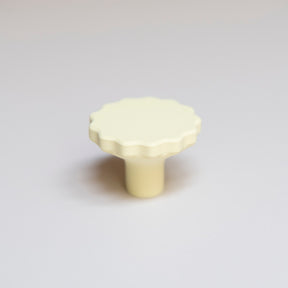 Bouton de meuble Manège couleur jaune pâle, créé en collaboration entre Studio Couleur et Polycoco, en bioplastique éco-responsable. 