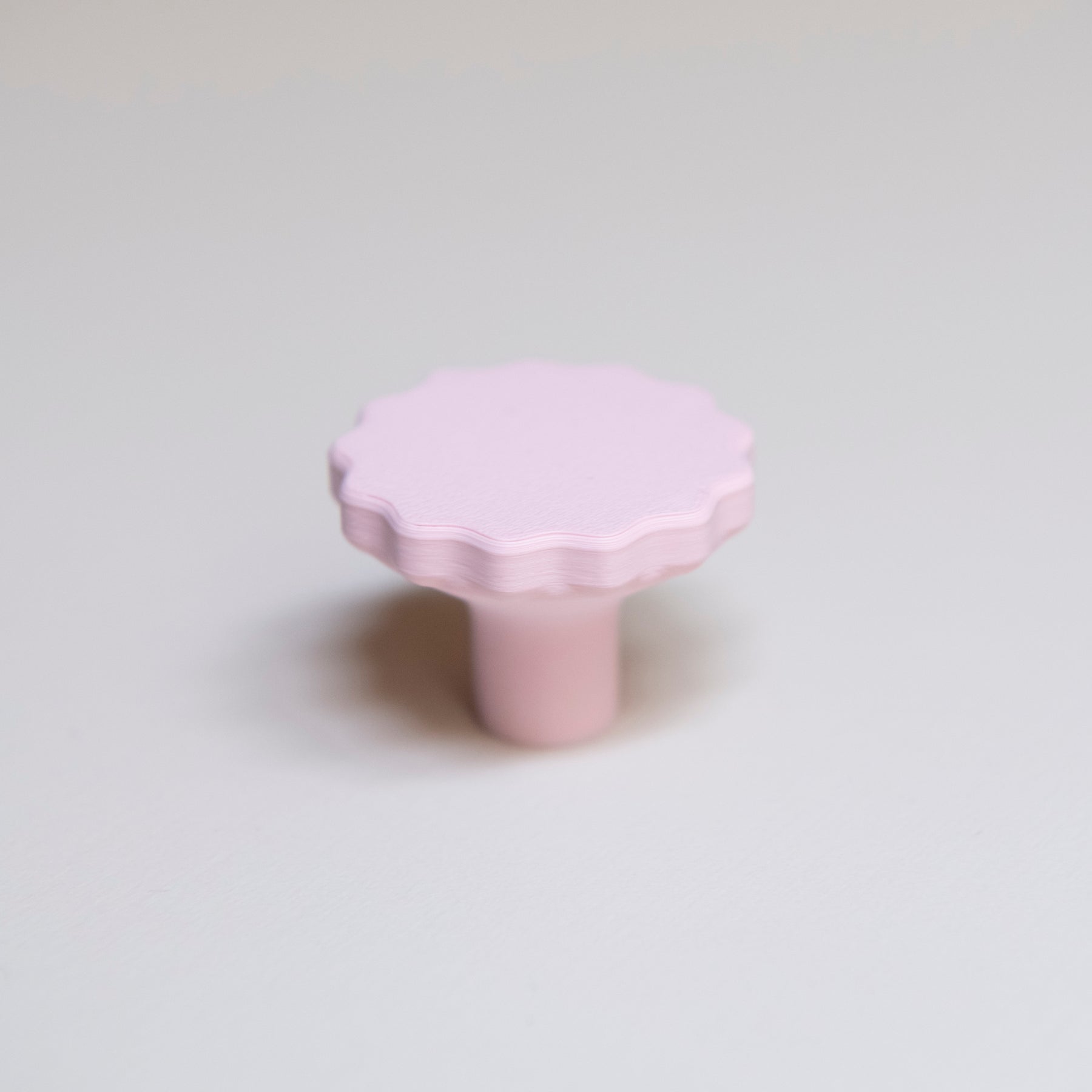 Bouton de meuble Manège couleur rose pâle, créé en collaboration par Polycoco et Studio Couleur, en bioplastique éco-responsable. 