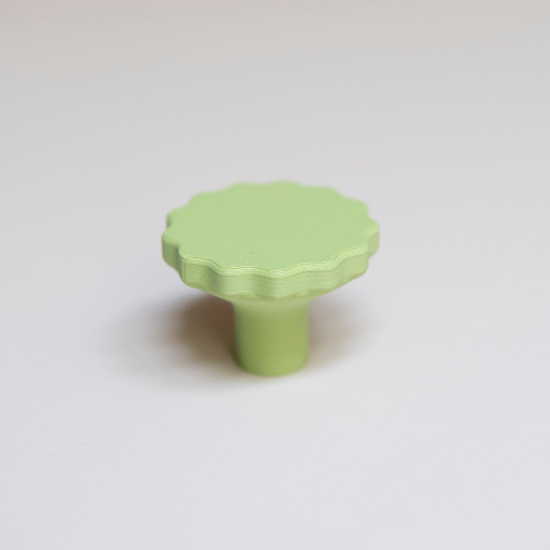 Bouton de meuble Manège couleur vert pistache, créé en collaboration par Polycoco et Studio Couleur, en bioplastique éco-responsable. 