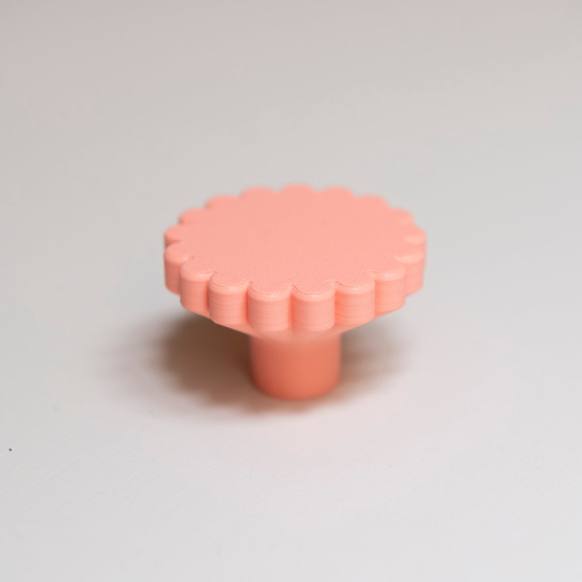 Bouton de meuble Marguerite couleur corail, créé en collaboration entre Studio Couleur et Polycoco, en bioplastique éco-responsable. 