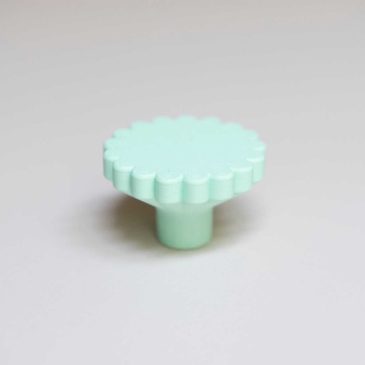 Bouton de meuble Marguerite couleur vert pâle, créé en collaboration entre Studio Couleur et Polycoco, en bioplastique éco-responsable. 