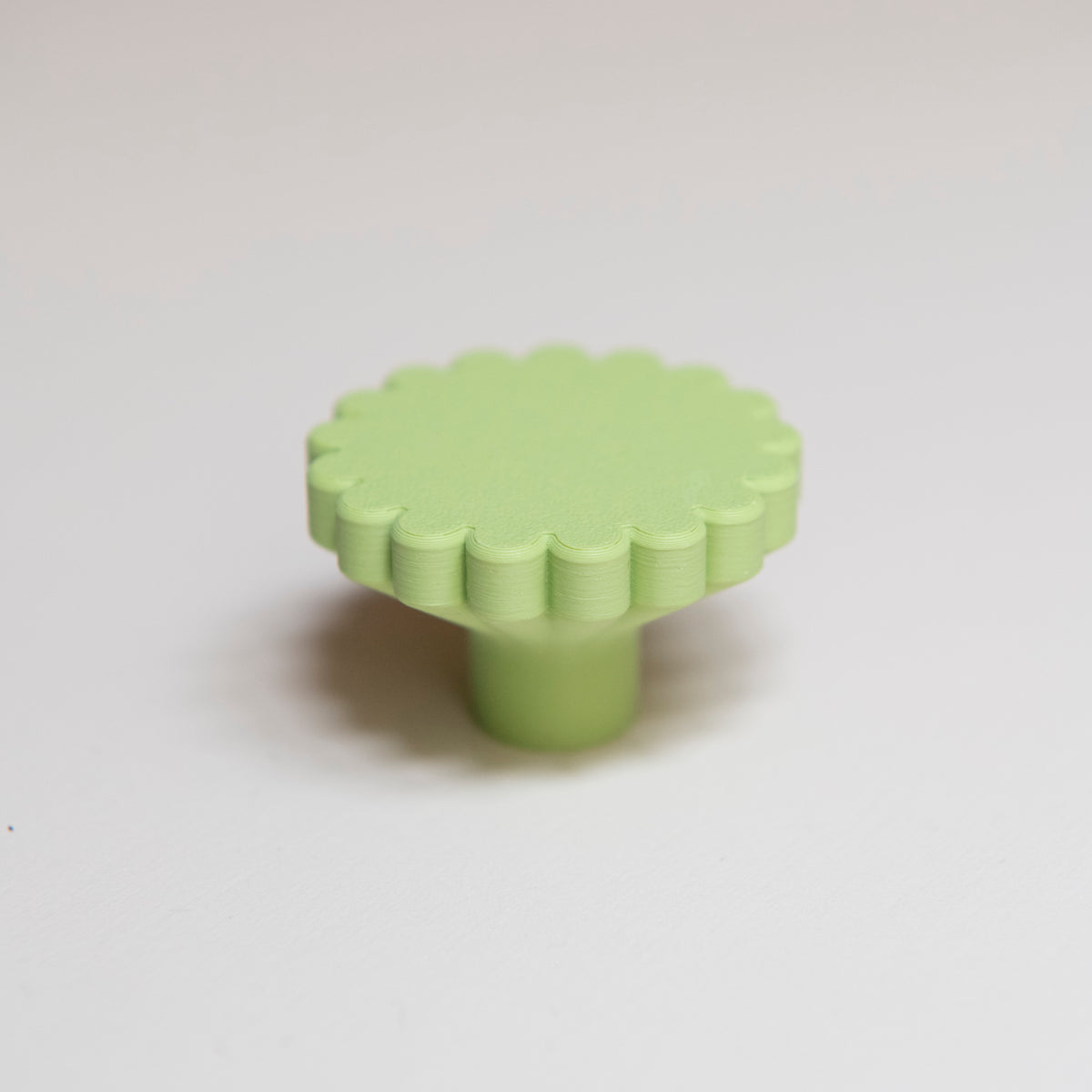 Bouton de meuble Marguerite couleur vert pistache, créé en collaboration entre Studio Couleur et Polycoco, en bioplastique éco-responsable. 