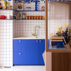 Cuisine aux façades bleu roi coloris "Mayol" Studio Couleur, posées sur des caissons Ikea Metod. Crédence en céramique blanches et étagères bleues coordonnées. Mitigeur et poignées en laiton.