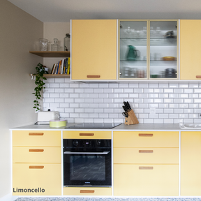 Cuisine aux portes et façades de tiroirs Studio Couleur jaunes, caissons Ikea Metod. Crédence en céramique et plan de travail blanc.