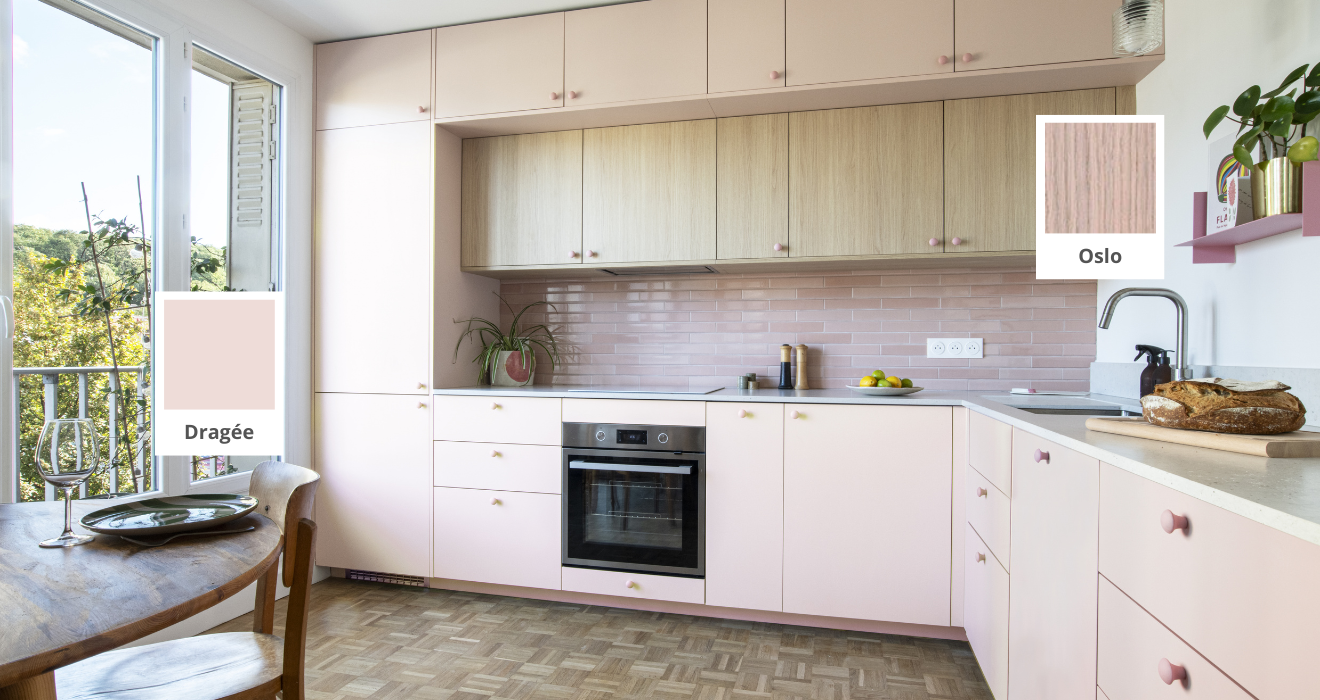 Réalisation Studio Couleur. Grande cuisine en L rose et bois clair avec meubles hauts, crédence rose et plan de travail blanc