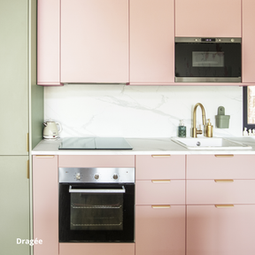 Cuisine encastrée entre colonnes, caissons Ikea Metod et facades roses et vertes Studio Couleur. Plan de travail veiné en céramique blanche