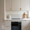 Petite cuisine beige coloris "Dune" Studio Couleur, avec caissons Ikea Metod. Poignées dorées et plan de travail en céramique gris.