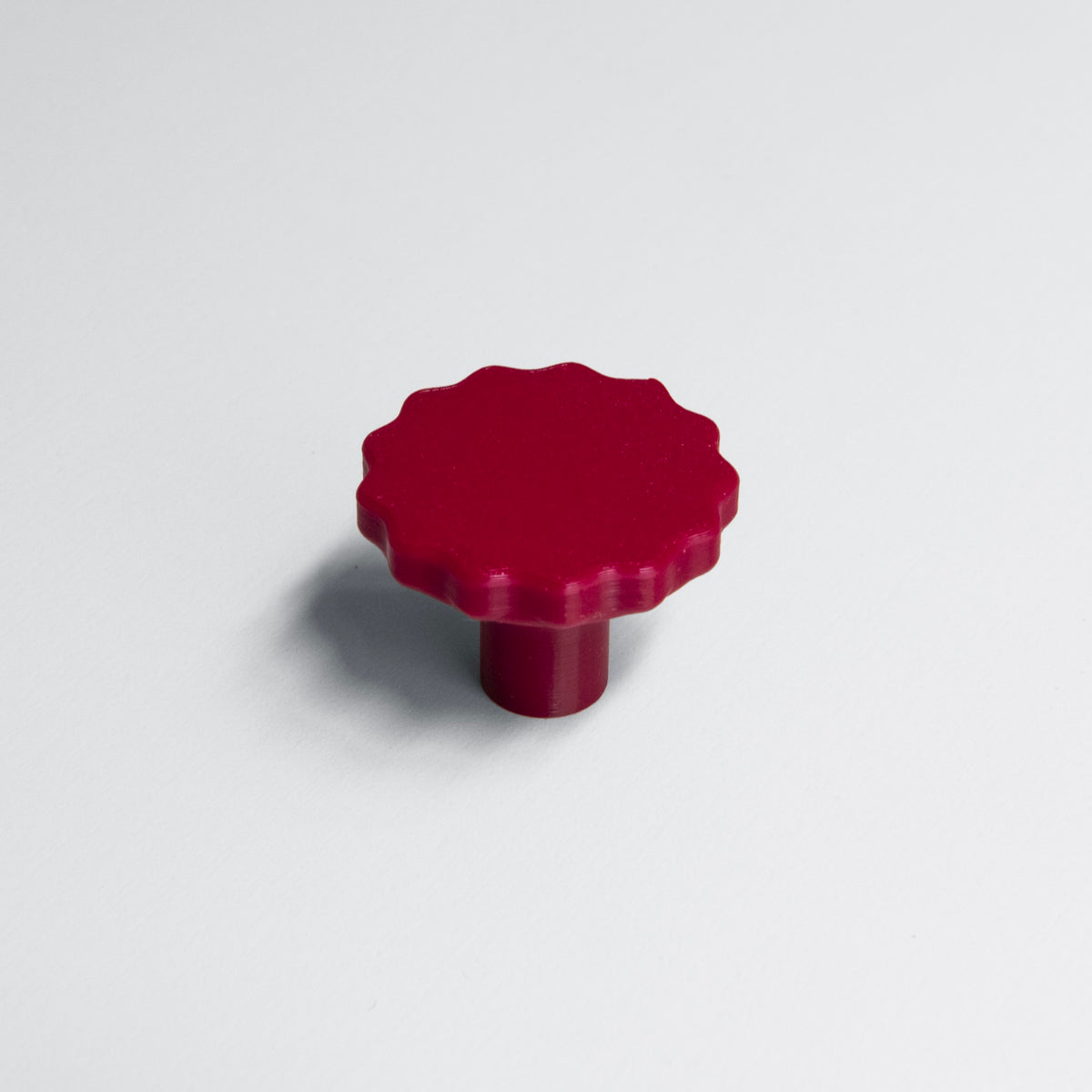Bouton de meuble Manège rouge coloris "Cerise", créé en collaboration par Polycoco et Studio Couleur, en bioplastique éco-responsable. 
