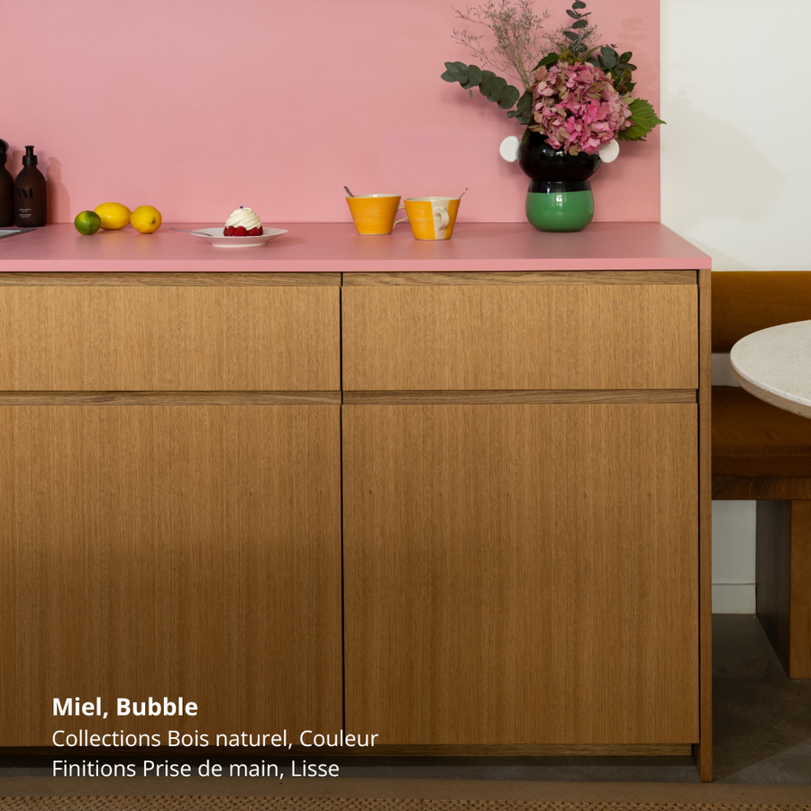 Meubles bas de petite cuisine Ikea Metod aux façades en chêne naturel clair coloris "Miel" Studio Couleur, avec prises de main intégrées toute longueur. Plan de travail et crédence rose bonbon coloris "Bubble".