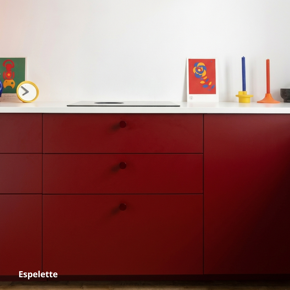 Petite cuisine linéaire basse, aux portes et façades de tiroirs rouge bordeaux, poignées bordeaux et plan de travail en céramique blanc