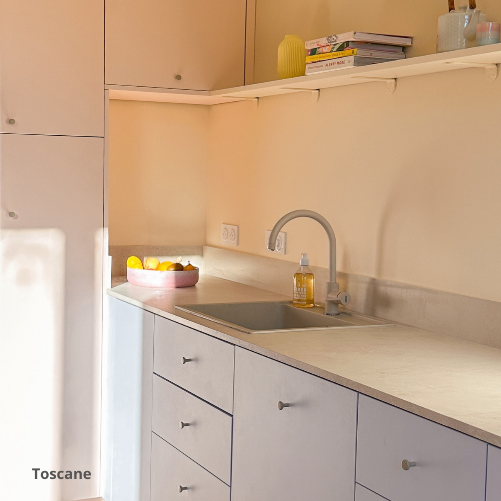 Plan de travail aspect marbre dans une cuisine rose et bleu pastel