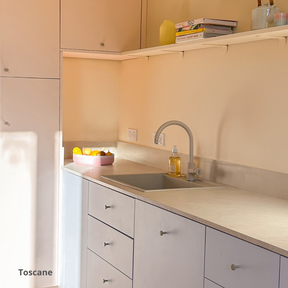 Plan de travail aspect marbre dans une cuisine rose et bleu pastel