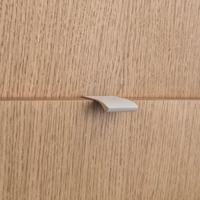 Poignée profilée pour meuble coloris beige, de 4cm de longueur. Elle se fixe discrètement sur le rebord des portes de cuisine.