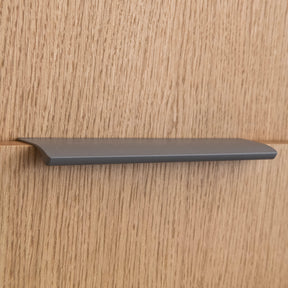 Poignée profilée pour meuble coloris taupe, de 20cm de longueur. Elle se fixe discrètement sur le rebord des portes de cuisine et d'armoires.