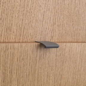 Poignée profilée pour meuble coloris taupe, de 4cm de longueur. Elle se fixe discrètement sur le rebord des portes de cuisine.