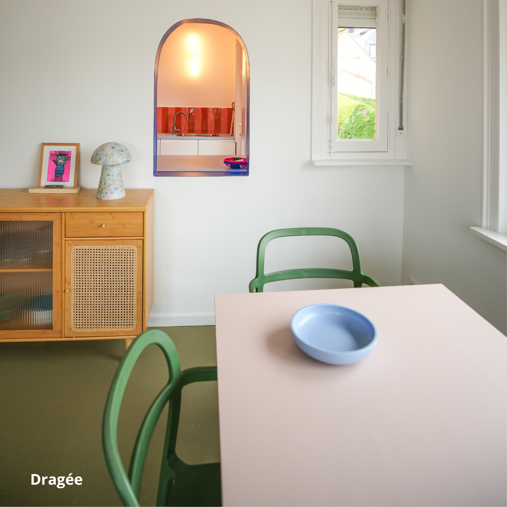 Table de salle à manger rose clair créée sur-mesure avec des panneaux Studio Couleur, et chaises vertes.
