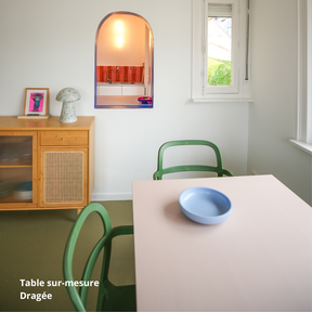 Table de salle à manger rose clair créée sur-mesure avec des panneaux Studio Couleur, et chaises vertes.